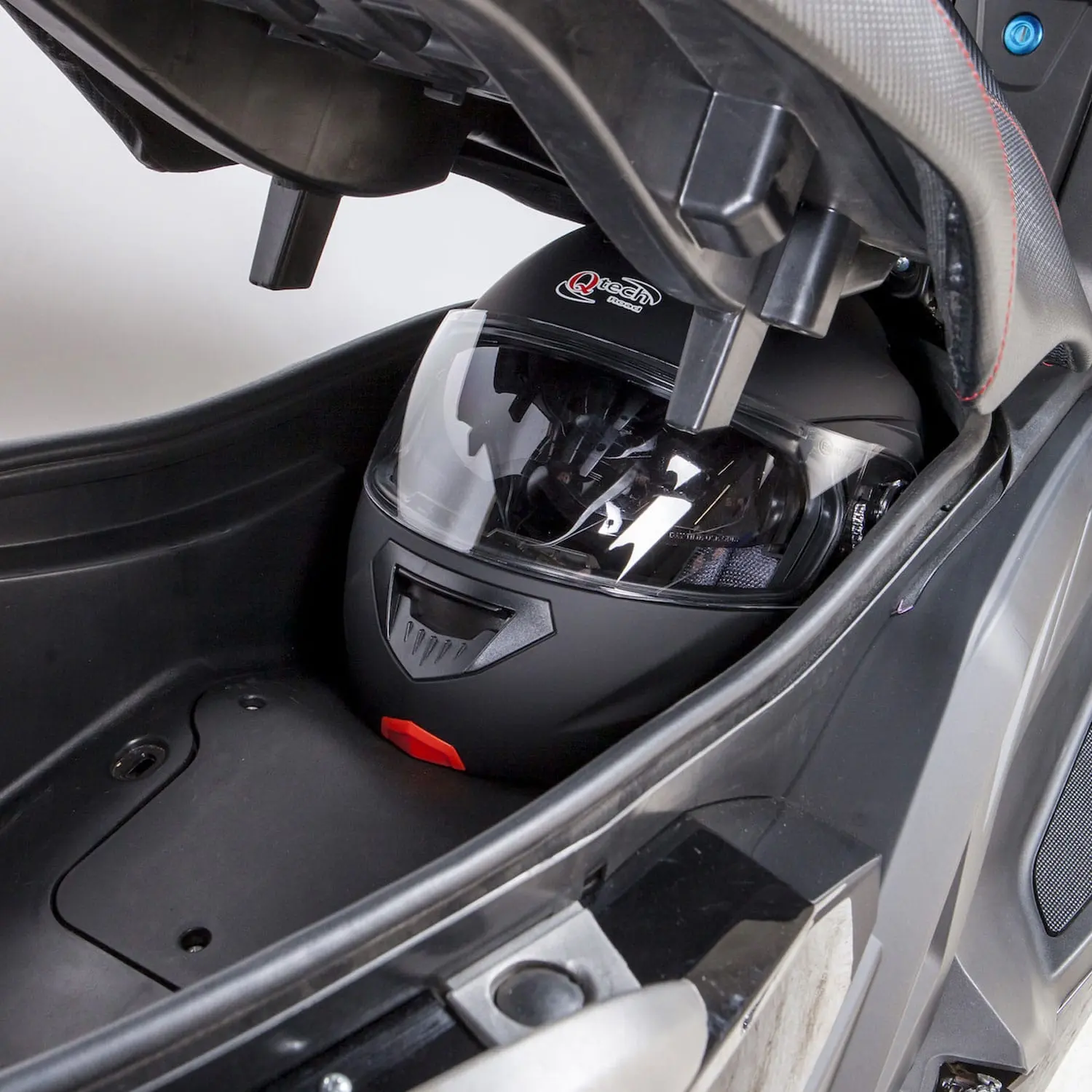 pink-fly-coffre Coffre du scooter électrique Pink Mobility Pink Fly Phase 3 avec casque intégral rangé sous la selle.